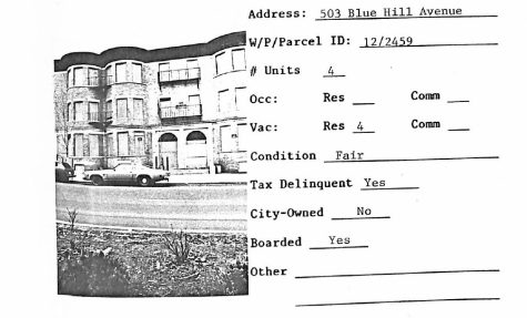 A scan of a property at 503 Blue Hill Avenue in Roxbury shows a property with four residential units reported. The three-story building has been boarded up. Information to the side of the photograph reveals the auditor found the building to be in fair condition, tax-delinquent and not city-owned.]